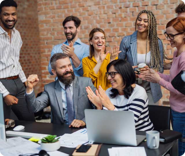 Diverse, smiling team celebrating at the office – inviting candidates to join All-Forward and tackle global challenges